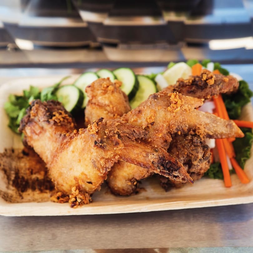 Crispy fried Fyre Wings served on a platter with sliced cucumbers, carrots, and lettuce.
